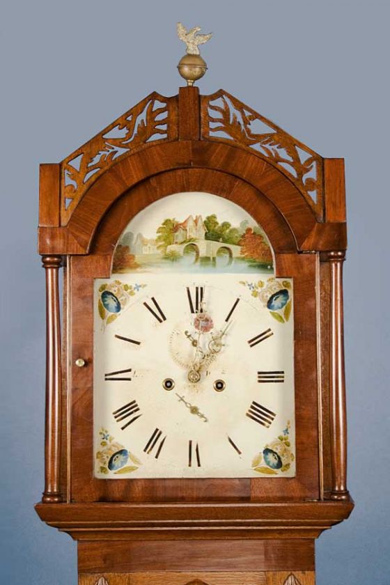 The top of the clock is adorned with carvings and a brass finial.